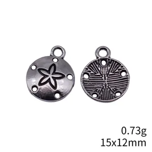 Close-up detail of the silver plated sand dollar charm showing front and back design.