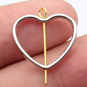 Nahaufnahme Detailansicht des geometrisch hohlen Herz Metall Anhängers mit goldenem Stift.