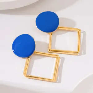 Boucles d'oreilles longues rondes en émail bleu et carrés géométriques dorés.