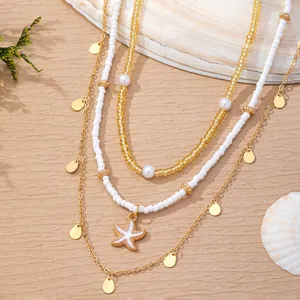 Close-up detail of multi-layer beach waist chain with white beads, pearls and starfish pendant.