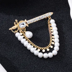 Gros plan détaillé sur une élégante broche épée dorée avec strass et chaînes de perles.