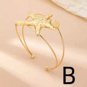 Elegante bracciale rigido dorato con stella marina e conchiglia stile mare estivo