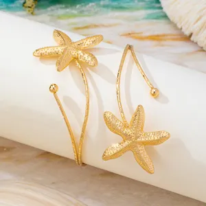 Goldfarbener Seestern Armreif Detail, offenes Metall Armband, Strand Resort Schmuck.