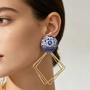 Gros plan de boucles d'oreilles tendance en porcelaine avec diamants géométriques multicouches.
