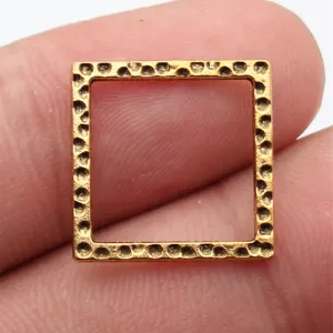 Detaillierte Nahaufnahme des goldenen quadratischen Hammeranhängers auf dem Finger.