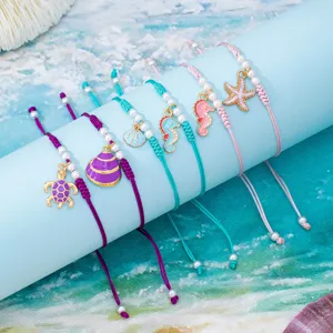 Set di cavigliere intrecciate fatte a mano con ciondoli di animali marini in smalto colorato.