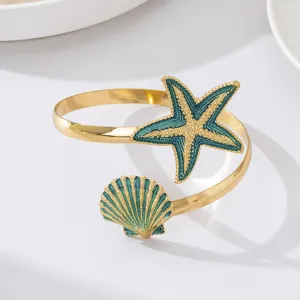 Gouden zeester schelp open armband, zomeroceaan stijl blauwe druppel olie metaal sieraden detail.