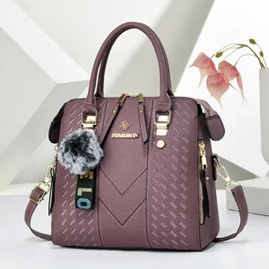 Stylish purple embossed tote bag with cute pompom charm, versatile casual shoulder bag.