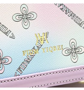 Close-up detail of gradient pastel handbag showing clover print, metal logo and clean leather trim.