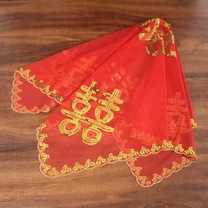 Close-up detail of traditional Chinese red wedding veil with golden sequin embroidery.