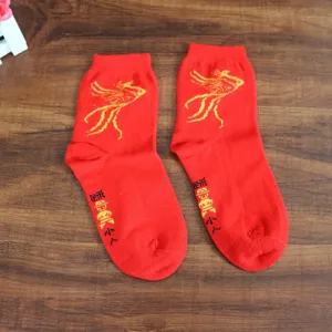 Détail de chaussettes en coton rouge avec motif phénix pour fête de mariage.