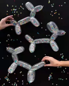 Transparent confetti magic balloons shaped into cute balloon dogs for party decor.