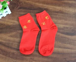 Détail de chaussettes de mariage rouges, design brodé, tissu en coton doux pour couples.