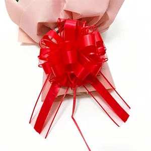 Close-up detail of the large red gift pull bow and pink wrapping paper for festival decor.