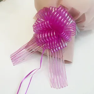 Gift wrapping ribbon bow detail view, decorative pull bow for holiday present packaging.