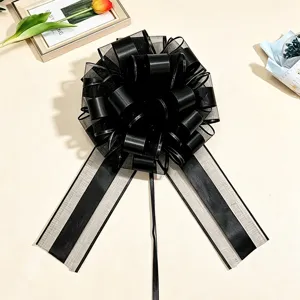 Dettaglio del fiocco in nastro decorativo nero che mostra la struttura floreale sferica e il tessuto.
