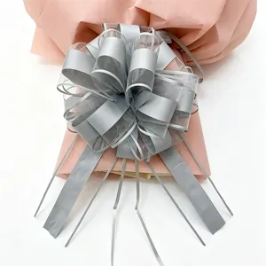 Large silver mesh gift bow with pink wrapping paper for Christmas and holiday decoration.