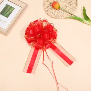 Red decorative gift bow detail with gold trim, perfect for festive floral wrapping and party decor.
