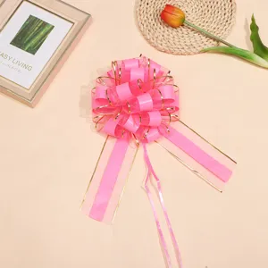 Large pink gift wrapping bow with gold trim, perfect for Christmas, floral decoration and weddings.