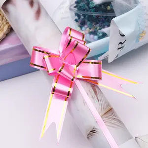 Pink ribbon bow with gold edge for gift wrapping, decorative floral packaging accessory.