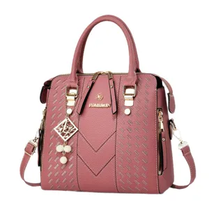 Pink leather handbag with woven pattern, gold hardware, top handles, and versatile crossbody strap.