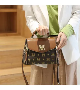 Detail view of a stylish Korean-style women's monogram crossbody handbag with brown flap.