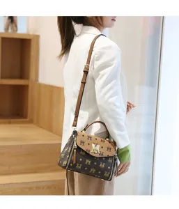 Detailed view of women's fashionable monogram shoulder bag with metal hardware and top handle.