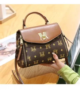 Detailed view of the brown PU leather monogram crossbody bag with metallic lock and handle.
