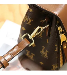 Close-up detail of a stylish brown monogram women shoulder bag with gold-tone hardware.