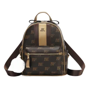 Stijlvolle bruine monogram vrouwen rugzak met voorzak en schattige witte pluche bal hanger.
