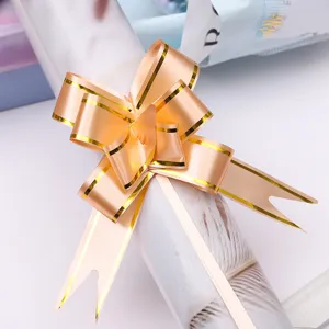 Golden gift bow ribbon for festive flower packaging and beautiful holiday present decoration.