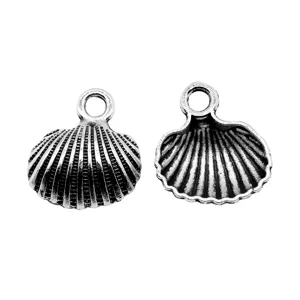 Silver shell charm detail view, antique metal jewelry making pendant, DIY accessory parts closeup.