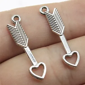 Primo piano di ciondoli a forma di freccia e cuore in argento accessori per gioielli.