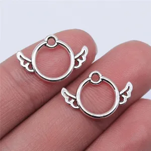 Close-up detail of antique silver metal wing ring pendant DIY jewelry crafting accessory.