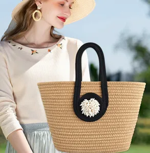 Strohhandtasche mit Perlenbesatz und schwarzem Henkel, ideal für Strandurlaub und den Alltag.