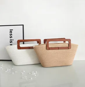 Detailansicht gewebter Baumwollseil-Tragetaschen mit Holzgriffen in Weiß und Beige.