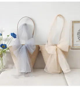 Geflochtene Strohtasche mit traumhafter Mesh-Schleife, ideal für elegante und stilvolle Anlässe.