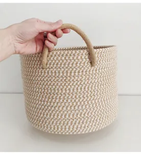 Detail view of woven cotton rope storage basket with double handles for home organization.