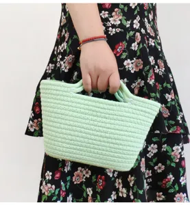 Nahaufnahme einer hellgrünen Baumwollseil geflochtenen Mini-Handtasche, detailgetreu präsentiert.