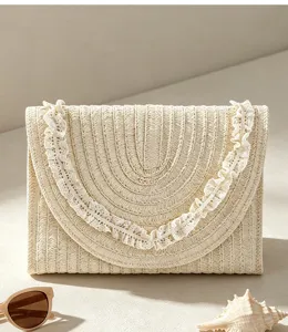 Nahaufnahme der beige gewebten Stroh-Clutch mit filigraner Borte, idealer Sommerstil.
