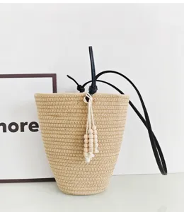 Geflochtene Stroh-Eimer Tasche mit schwarzem Lederriemen und Holzperlen Quaste Detail