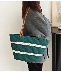Detailaufnahme der grün-weiß gestreiften Baumwollseil-Tragetasche mit braunen Leder-Schultergriffen.