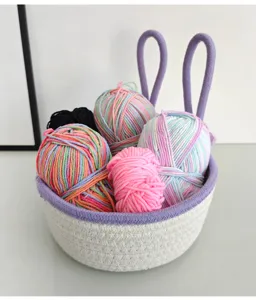 Cute cotton rope storage basket with bunny ears filled with colorful yarn balls for desktop use.