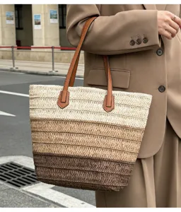 Nahaufnahme der geflochtenen Strohtasche mit Farbverlauf und praktischen Ledergriffen.