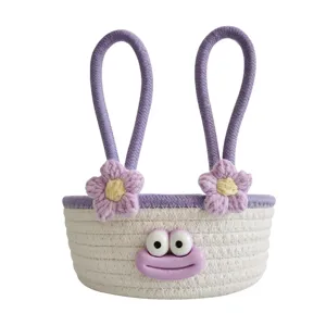 Cute cotton rope woven storage basket with cartoon face and handles for desktop organization.