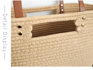 Close up detail of woven straw tote bag with leather handles and metal rivet decorations.