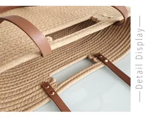 Woven straw tote bag detail showing texture, brown leather handles, metal rivets.
