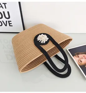 Detailansicht der gewebten Baumwollseil-Tasche mit Perlenblume und kontrastierenden Griffen.