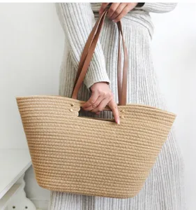 Detailed view of a casual woven tote bag with leather handles, ideal for beach and daily commuting.