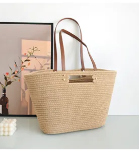 Casual woven tote bag detail showing texture, brown leather handles and sturdy construction.